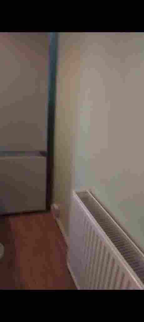 Room with double bed and fridge