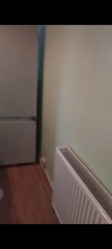 Room with double bed and fridge
