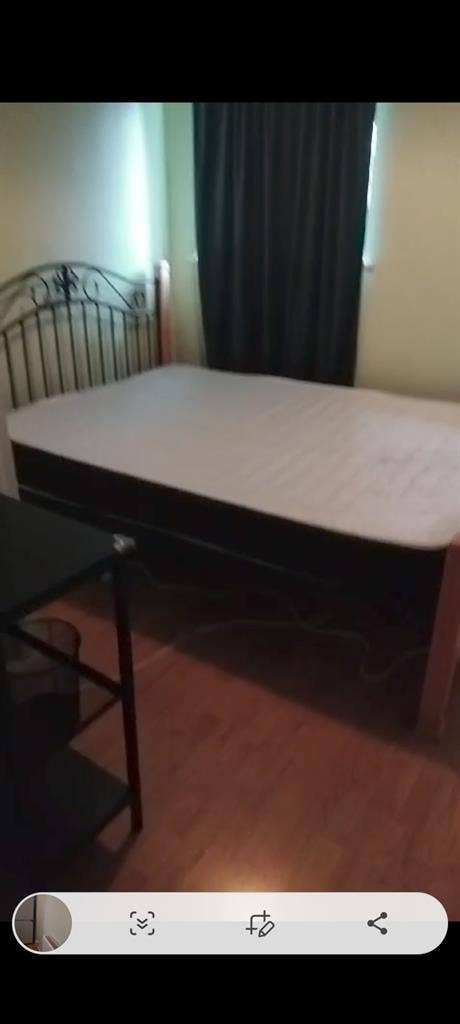 Room with double bed and fridge