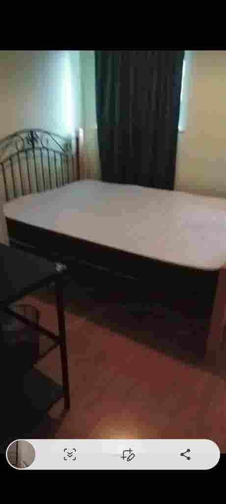 Room with double bed and fridge