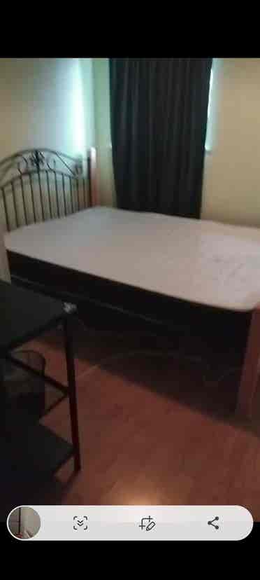 Room with double bed and fridge
