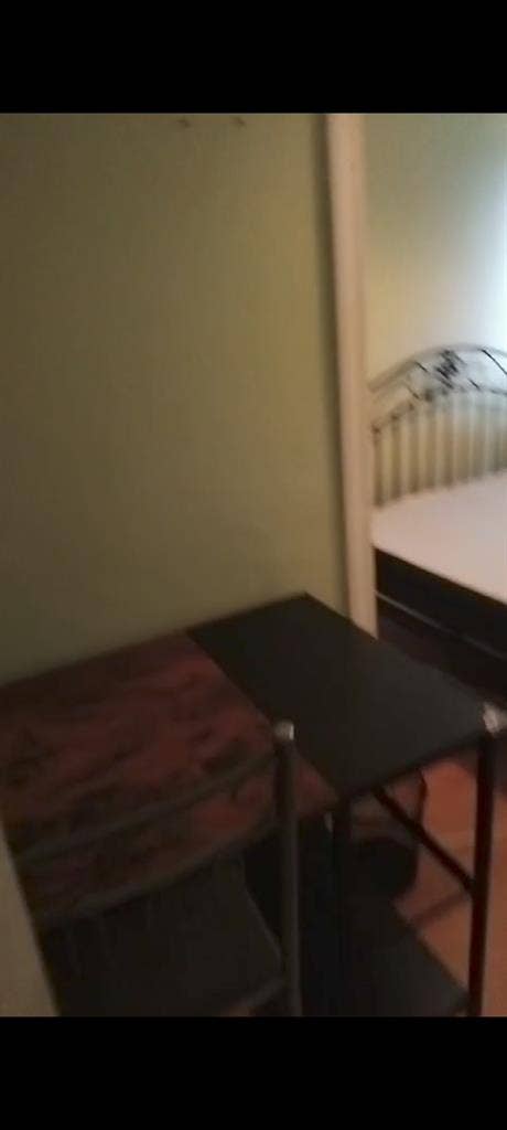 Room with double bed and fridge
