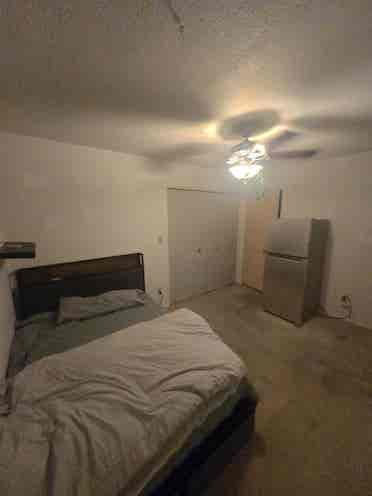 Bedroom with bed and fridge.