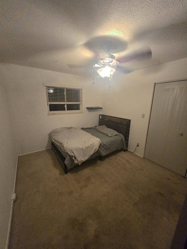 Bedroom with bed and fridge.