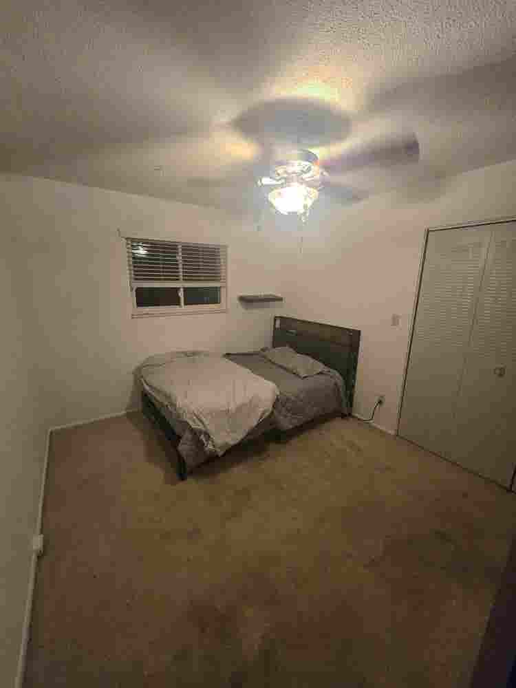 Bedroom with bed and fridge.