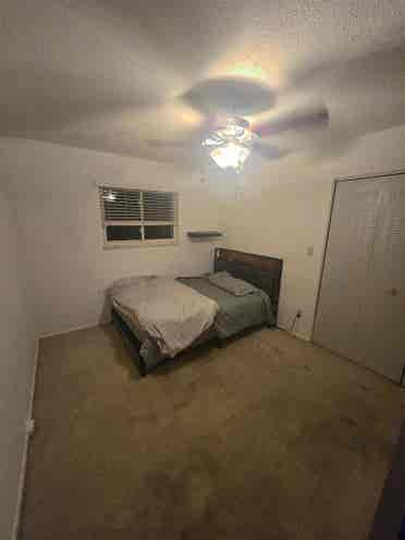 Bedroom with bed and fridge.
