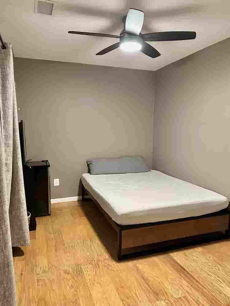 A basement level furnished bedroom.