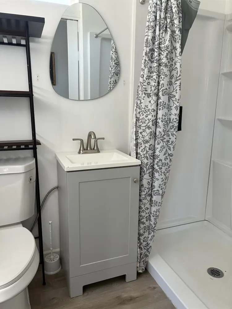 A bedroom with mini-split/fridge