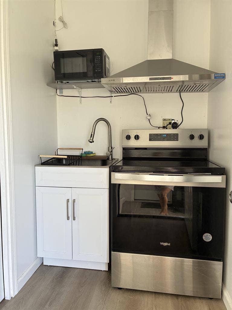 A bedroom with mini-split/fridge